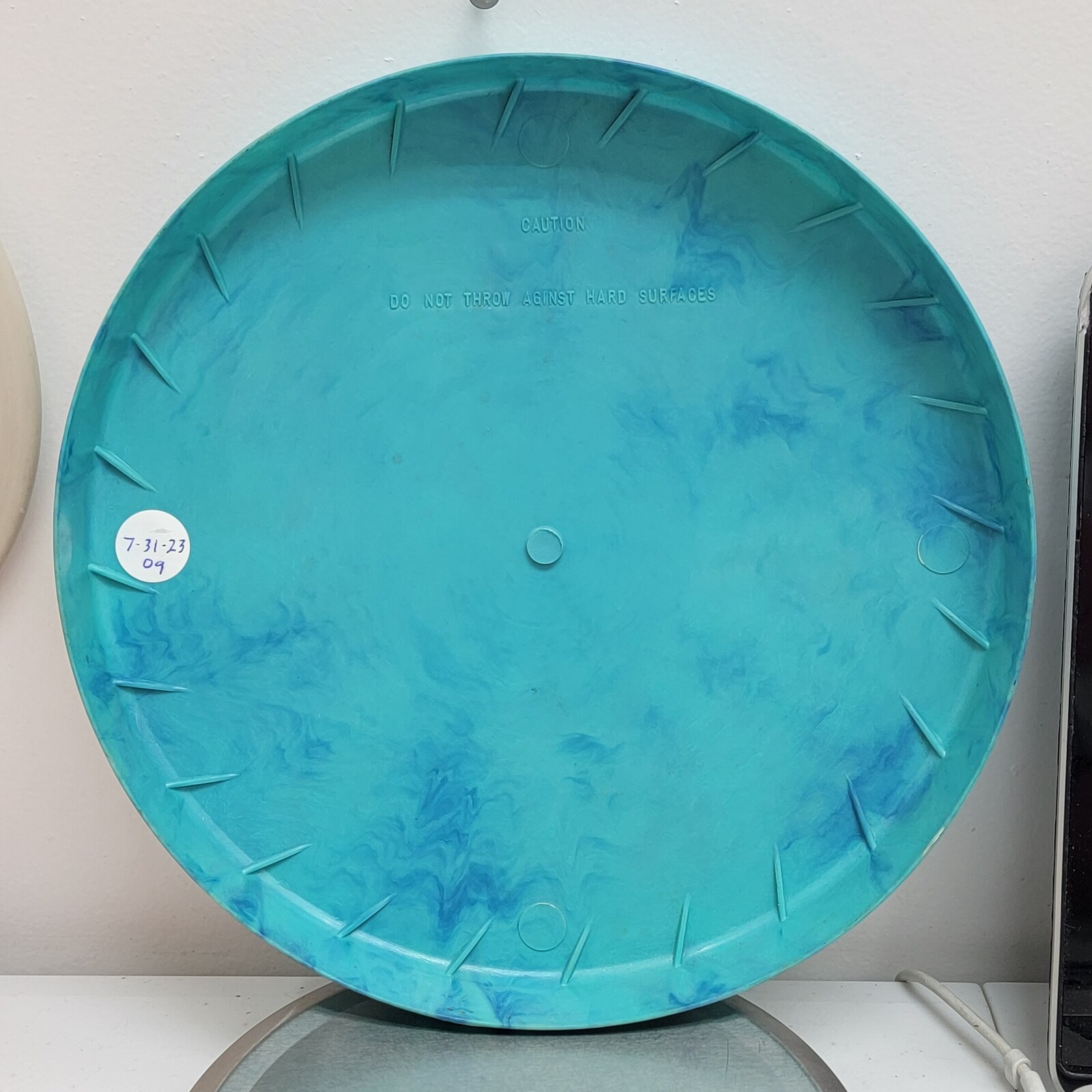 Back of the turquoise 1957 Space Saucer showing its circular form and molded underside.